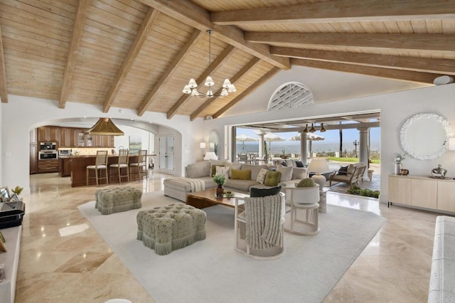5955 Lake Vista Dr, Bonsall, CA 92003 - living area with arched walkways, a notable chandelier, wooden ceiling, marble finish floor, and vaulted ceiling with beams