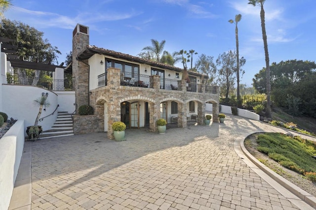 5955 Lake Vista Dr, Bonsall, CA 92003 - mediterranean / spanish-style house with stairway, curved driveway, a balcony, stone siding, and stucco siding