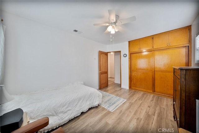 bedroom with visible vents, a ceiling fan, light wood finished floors, and a closet