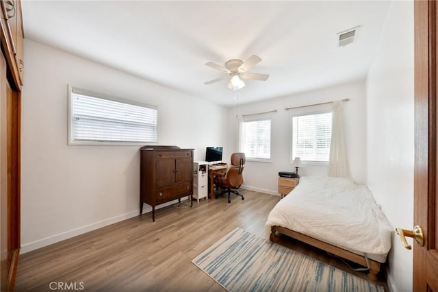 bedroom featuring a ceiling fan, baseboards, visible vents, and light wood finished floors