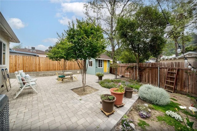 view of patio / terrace featuring a fenced backyard and an outbuilding