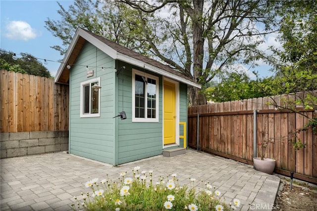 view of outdoor structure featuring an outbuilding and a fenced backyard