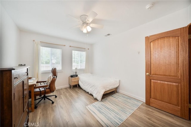 bedroom featuring ceiling fan, baseboards, visible vents, and light wood-style flooring