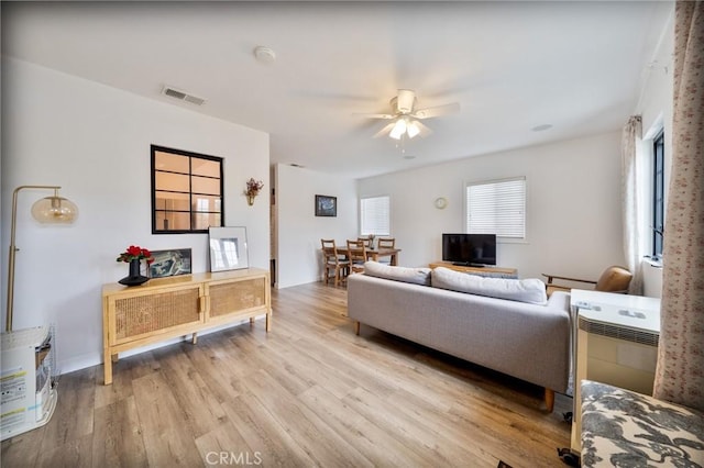 living room featuring ceiling fan, visible vents, and light wood-style floors