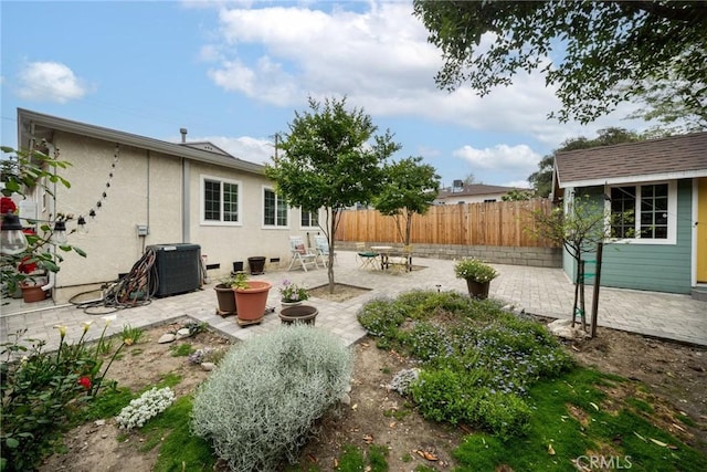 view of yard featuring a patio, fence, central AC unit, and an outdoor structure