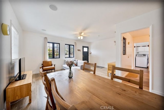 dining area with baseboards, washer / clothes dryer, wood finished floors, and ceiling fan