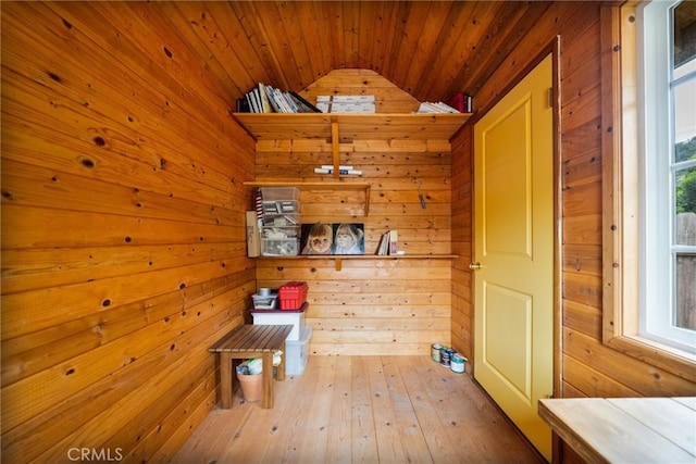 interior space with wooden walls, wooden ceiling, and lofted ceiling