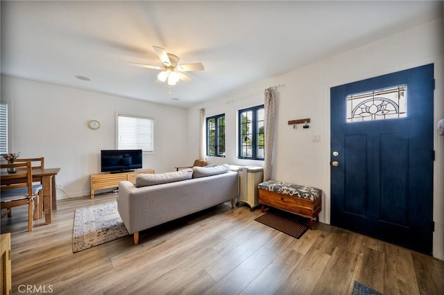 living room with light wood finished floors and ceiling fan