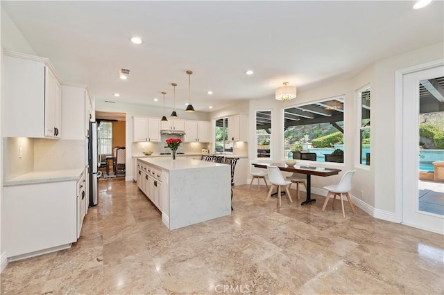 1560 Vandagriff Way, Corona, CA 92883 - kitchen with light countertops, white cabinetry, a kitchen island, baseboards, and pendant lighting