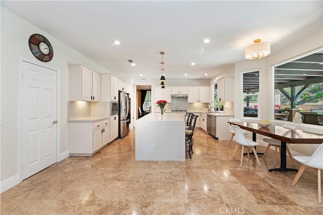 1560 Vandagriff Way, Corona, CA 92883 - kitchen featuring appliances with stainless steel finishes, a center island, light countertops, white cabinets, and recessed lighting