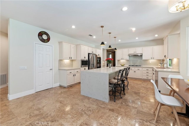 1560 Vandagriff Way, Corona, CA 92883 - kitchen featuring stainless steel appliances, under cabinet range hood, a kitchen island, a sink, and light countertops