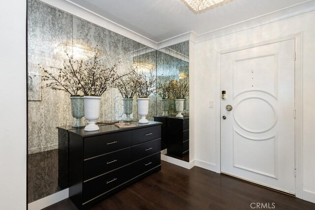 entrance foyer with dark wood-style flooring and ornamental molding