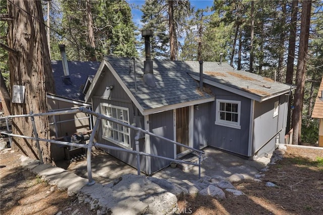 back of property featuring a shingled roof