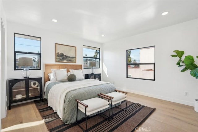 bedroom with recessed lighting, light wood-style floors, and baseboards