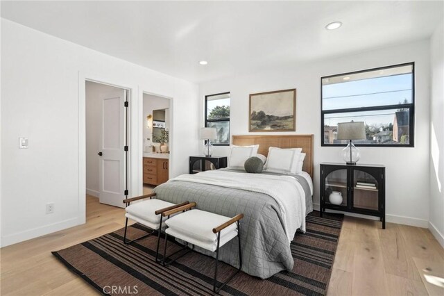 bedroom with recessed lighting, ensuite bath, light wood finished floors, and baseboards