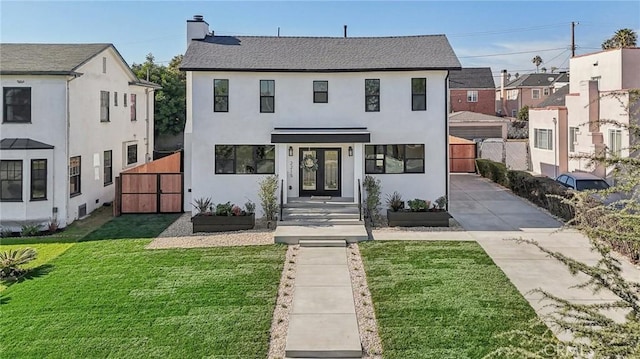 view of front of home featuring a gate, a front lawn, stucco siding, and french doors