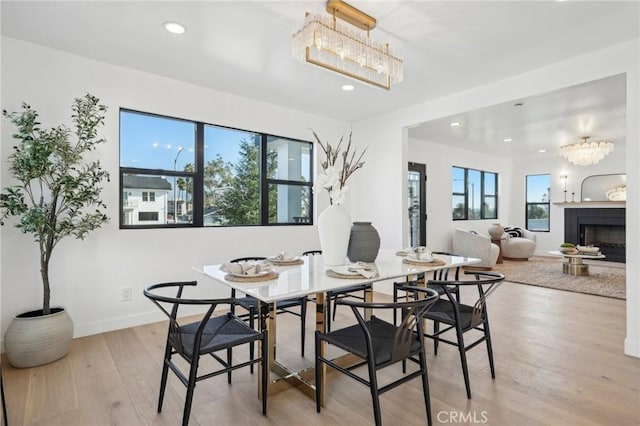dining space featuring light wood finished floors, an inviting chandelier, and recessed lighting