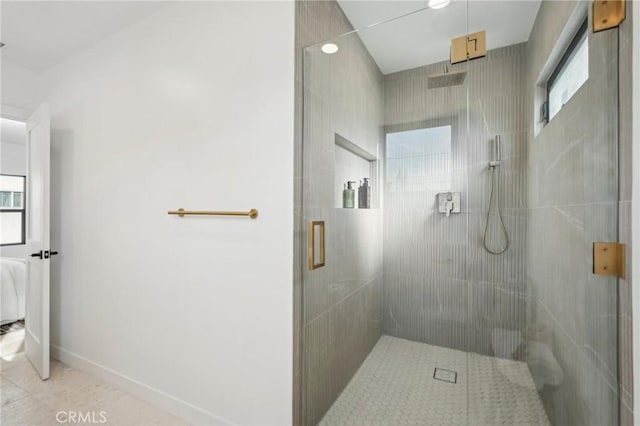 bathroom with baseboards, tile patterned flooring, and a shower stall