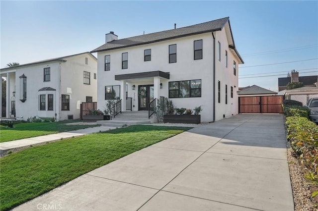 townhome / multi-family property featuring stucco siding, a gate, a chimney, and a front yard