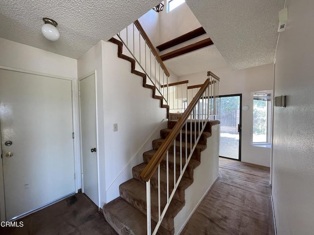 staircase featuring carpet and a textured ceiling
