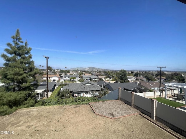exterior space with fence, a mountain view, and a residential view