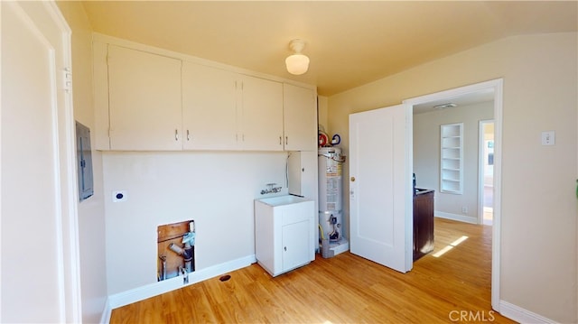 laundry room featuring electric panel, gas water heater, light wood finished floors, and built in shelves