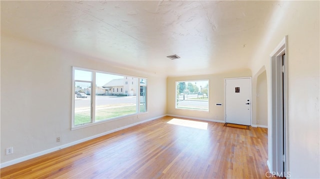spare room featuring baseboards, visible vents, and light wood-type flooring