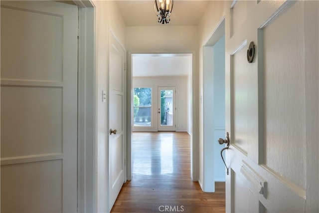 hallway featuring wood finished floors and baseboards