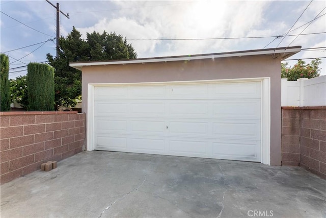 detached garage featuring fence