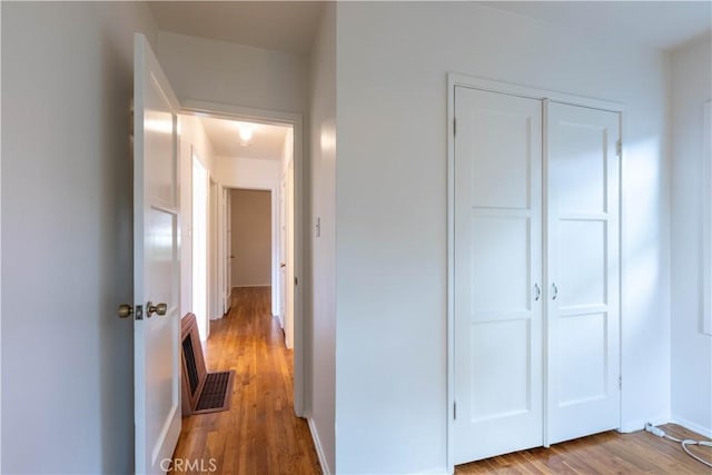 corridor featuring baseboards and wood finished floors