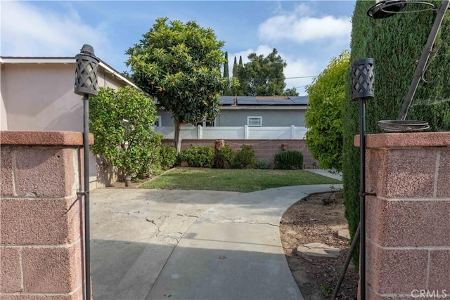 view of gate with fence and a patio