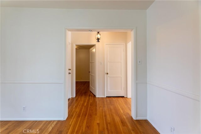 unfurnished room featuring baseboards and wood finished floors