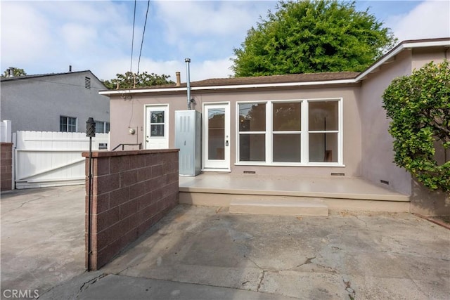 back of house featuring fence, a patio area, and stucco siding