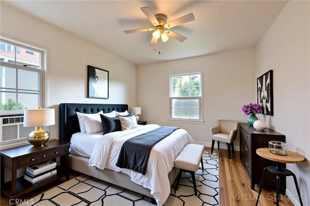 bedroom with light wood-style flooring, baseboards, and ceiling fan