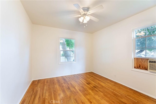 unfurnished room featuring light wood-style flooring, baseboards, ceiling fan, and a healthy amount of sunlight