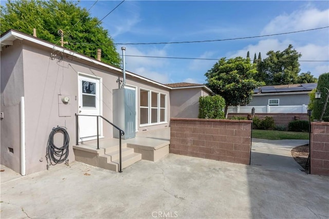 back of property with stucco siding, fence, and a patio