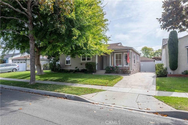 obstructed view of property featuring concrete driveway and a front yard
