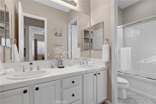 bathroom featuring tile patterned flooring, a sink, double vanity, and toilet