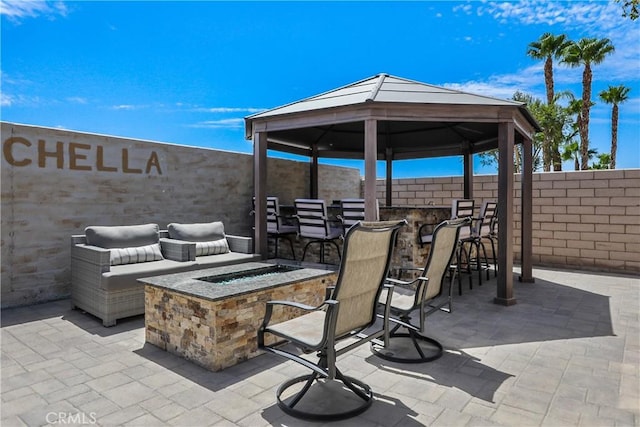 view of patio featuring a fire pit, outdoor dry bar, a gazebo, and fence
