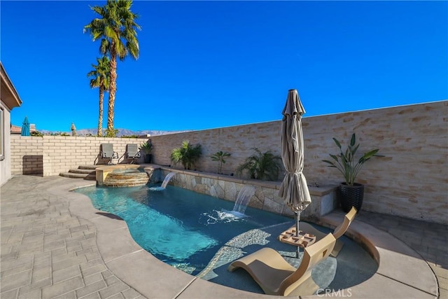 view of pool featuring a pool with connected hot tub, a patio, and a fenced backyard