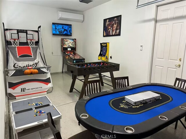 playroom featuring baseboards, finished concrete flooring, and a wall mounted air conditioner