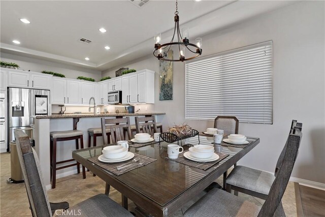 dining room featuring recessed lighting, a raised ceiling, visible vents, baseboards, and a notable chandelier