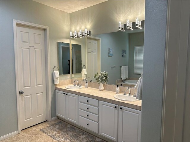 bathroom with tile patterned floors, a garden tub, a sink, and double vanity