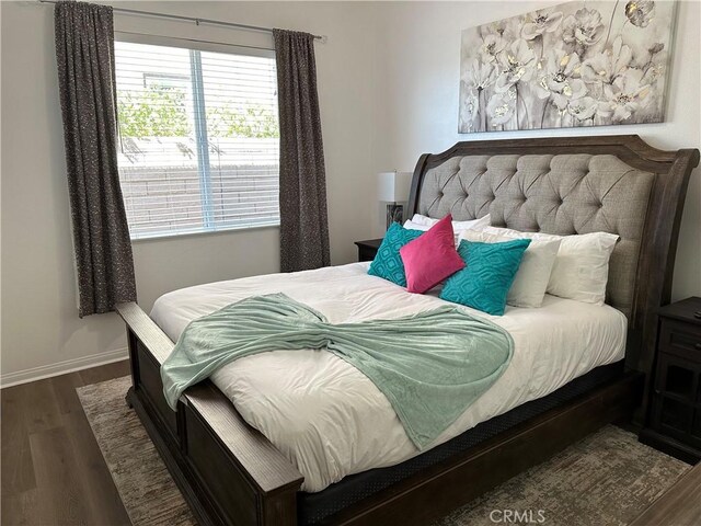 bedroom featuring wood finished floors and baseboards