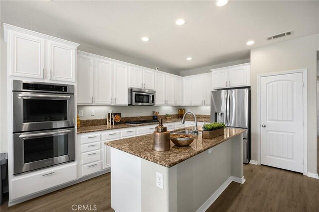 kitchen featuring dark wood finished floors, visible vents, white cabinetry, and stainless steel appliances