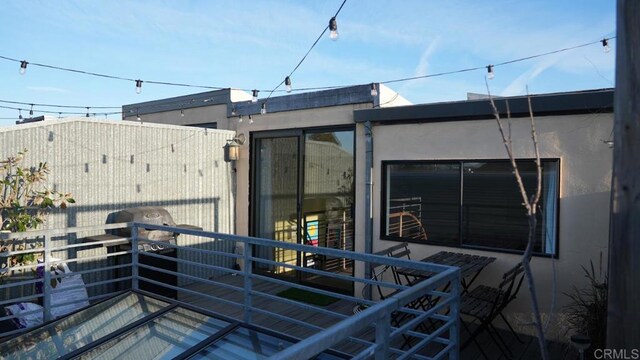 property entrance featuring stucco siding and a balcony