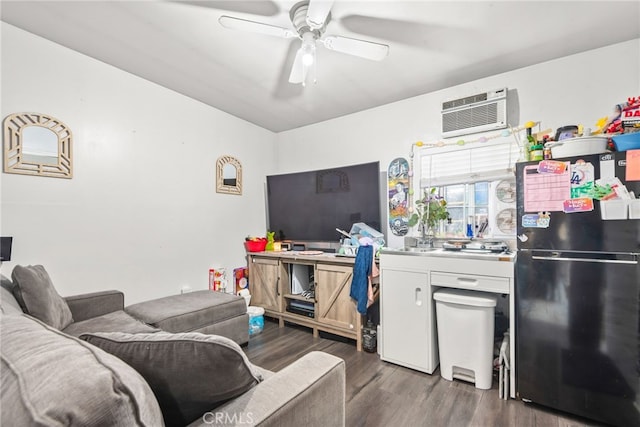 kitchen featuring freestanding refrigerator, a ceiling fan, a wall mounted AC, and wood finished floors