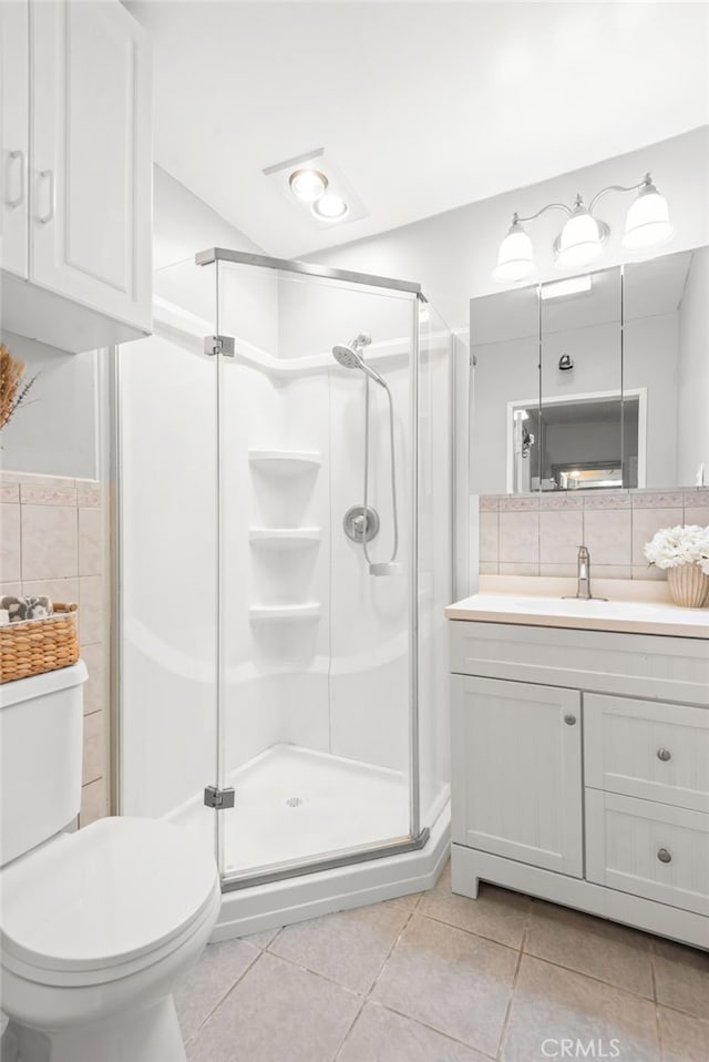 bathroom with toilet, tile patterned floors, a shower stall, and vanity