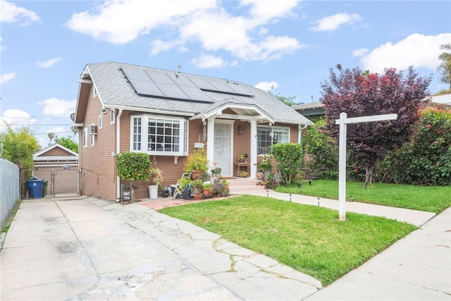 bungalow with fence, a shingled roof, a front yard, a gate, and solar panels