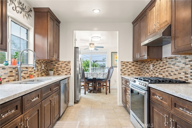 kitchen featuring a sink, stainless steel appliances, a ceiling fan, backsplash, and under cabinet range hood